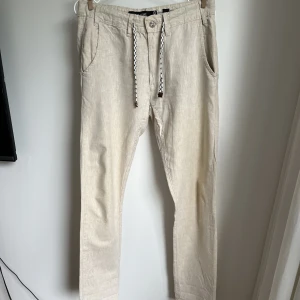 Linnebyxor  - Beiga linnebyxor storlek S  Längd ben: 32 tum (Innerlängd ben: 82,5 cm)