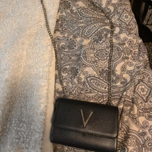 Valentino väska - Ja köpte denna väska förra året för 750kr men säljer för 350 använt ett fåtals gånger och den är super fin. Färgen är i grå