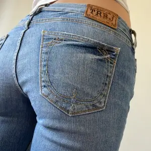 Ljusblåa jeans från true religion Låg midja Lite stretchiga Design på  bakfickorna  Innebenslängd 83 cm 37 cm tvärs över midjan 
