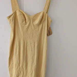 Klänning i fin ljusgul färg  - Oanvänd söt klänning från beyond retro i stretchigt material. köptes för ca 250 kr. Står ej storlek men den passar mig och jag har S eller 38. 