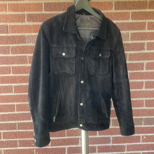 Jofama x King Svart Mockajacka - En svart mockajacka i storlek 50/M. Tillverkad i sverige. Nypris: 2790 sek   https://www.kingmagazine.se/king-lanserar-ny-jacka-med-jofama/