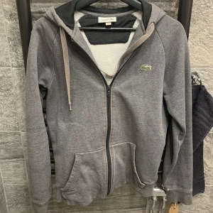 Lacoste kofta - Lacoste kofta i storlek xs säljer då den är för liten på mig, okej skick. Det står lacoste på luvan vilket är skitsnyggt plus färgen är jättefin.