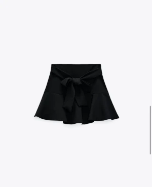 Svart kjol från zara - Svart byxkjol från zara med band som kan knytas till rosett på sidan. Inga hål, fläckar osv. Storlek L men är vanligtvis M så borde passa på de som brukar ha M. 