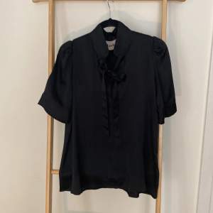 Superfin svart sidentop fr Kerber.  Strl 36 Knyts i halsen Ganska djup v-ringning 100% silke Nypris 1900kr.  https://www.kerber.se/products/knot-your-blouse-5