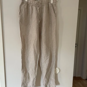 Linnebyxor - Kritstrecksrandiga beiga linnebyxor, använda 2-3 gånger, ankellängd, säljer pga storlek ej passar 