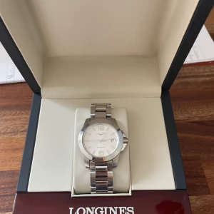 Longines klocka - Longines conquest klocka i mycket fint skick. Inga tydliga defekter på varken urtavlan eller bandet. Skriv vid fler frågor eller intresse. Tar även bud!