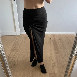 Kjol med slits - Lång kjol men snörning och slits. Använd fårtal gången. Går ned till ankeln och slitsen går att ändra med snörena.