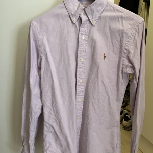 Ralph Lauren skjorta - Oxfordskjorta i ljuslila från Ralph Lauren. Hämtas i Stockholm