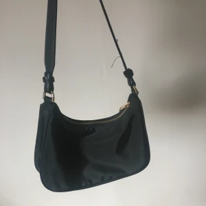 Väska - Säljer en svart väska som inte kommer till användning längre💗Jätte bra utrymme och i bra skick! Finns vissa lösa trådar på axelbandet men inget man lägger märke till, dessutom lätta att klippa av 😊Fråga gärna om du vill ha fler bilder så fixar jag!