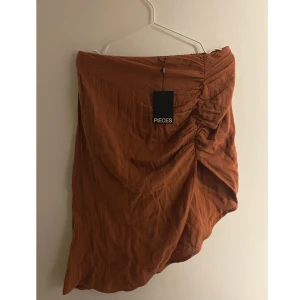 Kjol med slits - Helt ny minikjol från Nelly i storlek L. Kjolen har en fin slits. Prislappen är kvar och endast testad. 