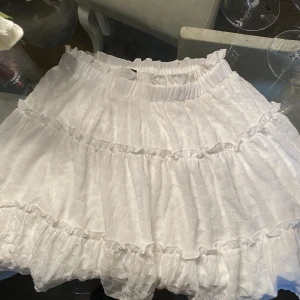 Kjol med volanger  - Fin och söt sommarkjol. Använd Max 4 ggr dvs väldigt fint skick.  Inte genomskinlig 