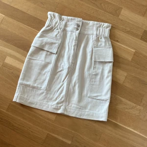 Kjol  - Beige kjol i jeans med snygga fickor och detaljer.  I mycket gott skick. 