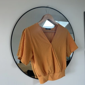 Omlott blus - Smickrande blus i omlott med knytning baktill. Senapsgul/orange färg. 