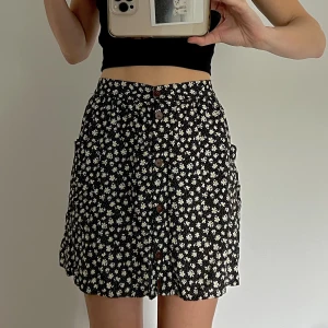 blommig kjol - svart kjol med vita blommor från urban outfitters i strlk S. nästan aldrig använd men för fin för att ligga o samma. 🤍