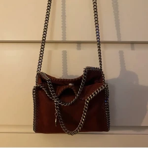Stella mccartney väska tiny - Säljer min snygga väska från stella mccartney tiny i färgen burgundy. Så fin och användbar, kan tänka mig att byta till en annan färg. Väskan är använd men i fint skick. Buda från 3000kr