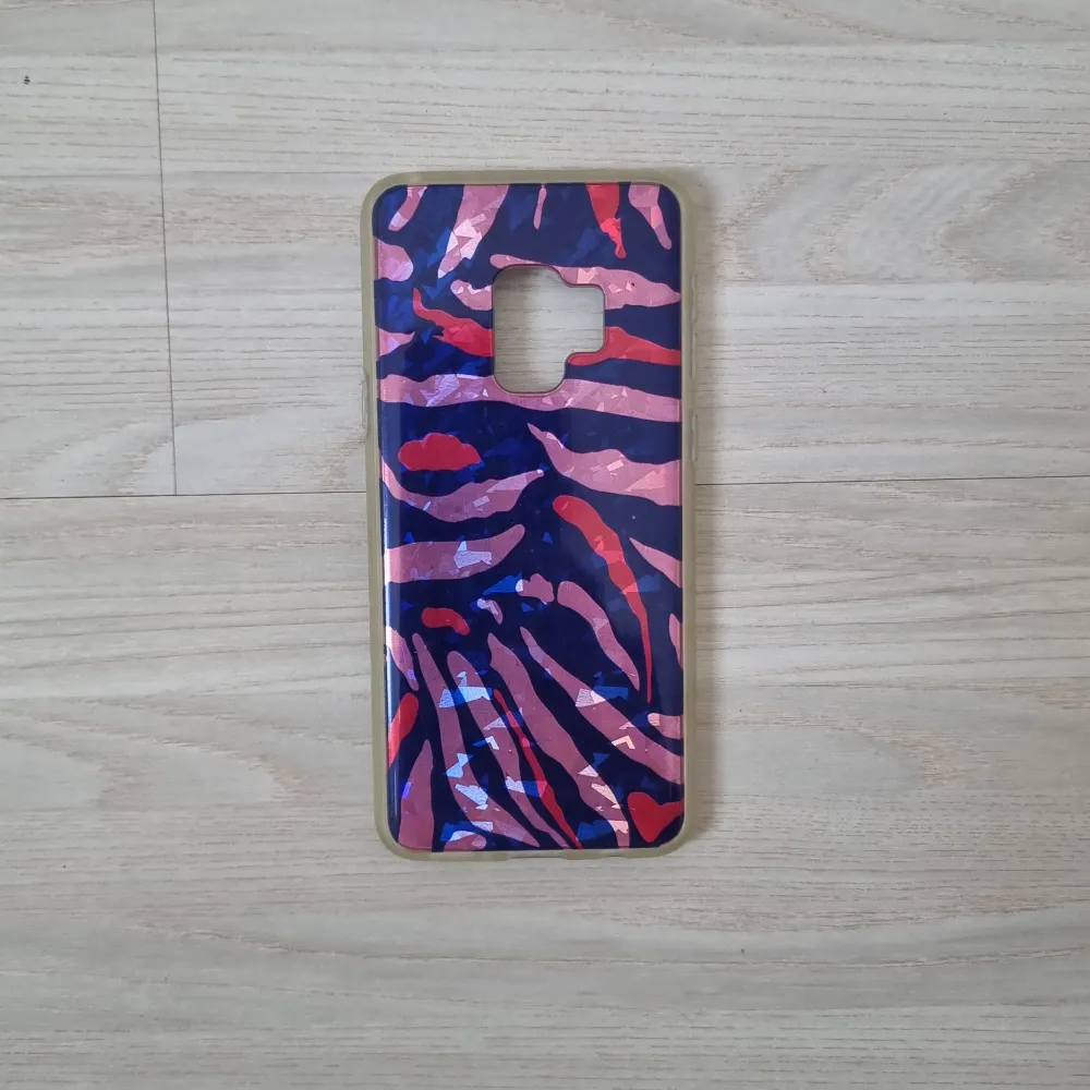 Coolt telefonskal till Samsung Galaxy S9, köpt på flying tiger och är i bra skick. Har tigerränder i rosa, mörkblå och rött.. Övrigt.