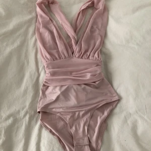 Rosa body - Supersnygg rosa body. Djup v-ringning och öppen rygg. Aldrig använd. 