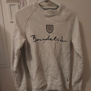 Långärmad tröja - Vit/ljusgrå lånhärmad tröja med märke på 