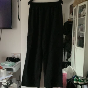 Svarta byxor med fickor - Inte använda men har ett hål fram i resåren (se sista bilden) 