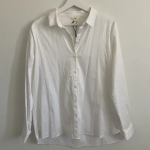 Vit skjorta från Object  - Vit skjorta från Object (köpt på Nelly.com), storlek 38. Helt oanvänd i nyskick. Lappen sitter kvar. Har 2 trådar som hänger från sömmarna (den var så när jag fick den). Köpt för 399kr säljer för 120kr
