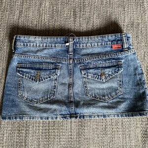 Lågmidjad jeanskjol - Lågmidjade jeanskjol med snygga detaljer där bak ❤️‍🔥Strl 38 o passar mig med höftmått 86 cm (passar mindre också) 🪩Köp direkt: 400