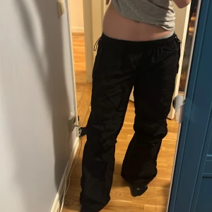 Parachute pants - Jättesnygga lågmidjade parachutepants från BERSHKA i storlek xs! De har fickor i fram (se bild 3) och går att spänna in både vid bena så de blir mer utsvängda/insvängda och även i midjan. Säljer då de inte riktigt är i min stil längre!💕 