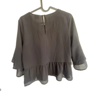 Svart blus m volanger  - Säljer denna superfina, loose blusen från Gina i strl XS🖤knappt använd men jätteskönt material! DM för frågor/bilder, köpare står för frakt 🚚 