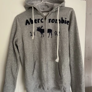 Hoodie - Grå Hoodie med blå text. Strl XL men mer som M liten L