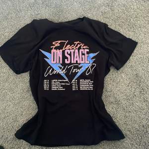 Cool vintage T-shirt med tryck. “Electric on stage world tour -87” världsturné T-shirt. Bra skick, sällan använd från Gina Tricot 