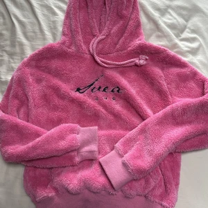 Fluffig Svea hoodie  - Rosa fluffig Svea hoodie. Oversize på mig som har XS. Köpt för flera år sedan och har använt den typ en gång sedan dess. Frakt ingår inte i priset. 