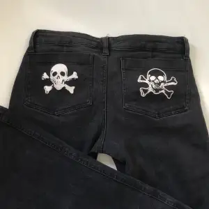 Svarta jeans från Tripp nyc. Dom har dragkedjor framme på låren och döskallar bak på fickorna. Sitter lågmidjat och står storlek 9, skulle säga att de motsvarar storlek xxs-xs. Mer åt straight leg hållet. Jättebra skick! Dm för fler bilder eller frågor🤍