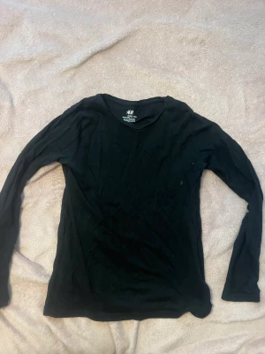 Svart långärmad  - Svart tajt långärmad tröja från H&M. Stolek 134/140