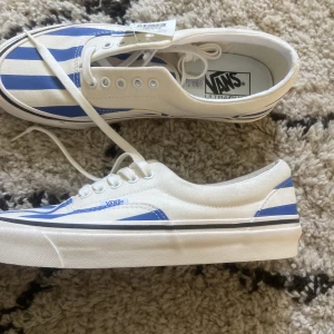 Vans, blå-vit randiga   - Ett par helt oanvända (prislappen finns kvar!) skor från Vans. Köpta i USA för 39.99$ men säljs för 150kr + frakt (ca 80kr) :) storleken: US Men - 9.5, US Women - 11.0 