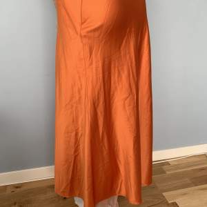 Orange slipkjol från NAKD, strlk 36. Funkar lågmidjat på en XS (midjemått, 72 cm). Dragkedja i sidan. Kjolen har på två ställen en liten tråddragning. Skriv om ni vill ha bilder på det!