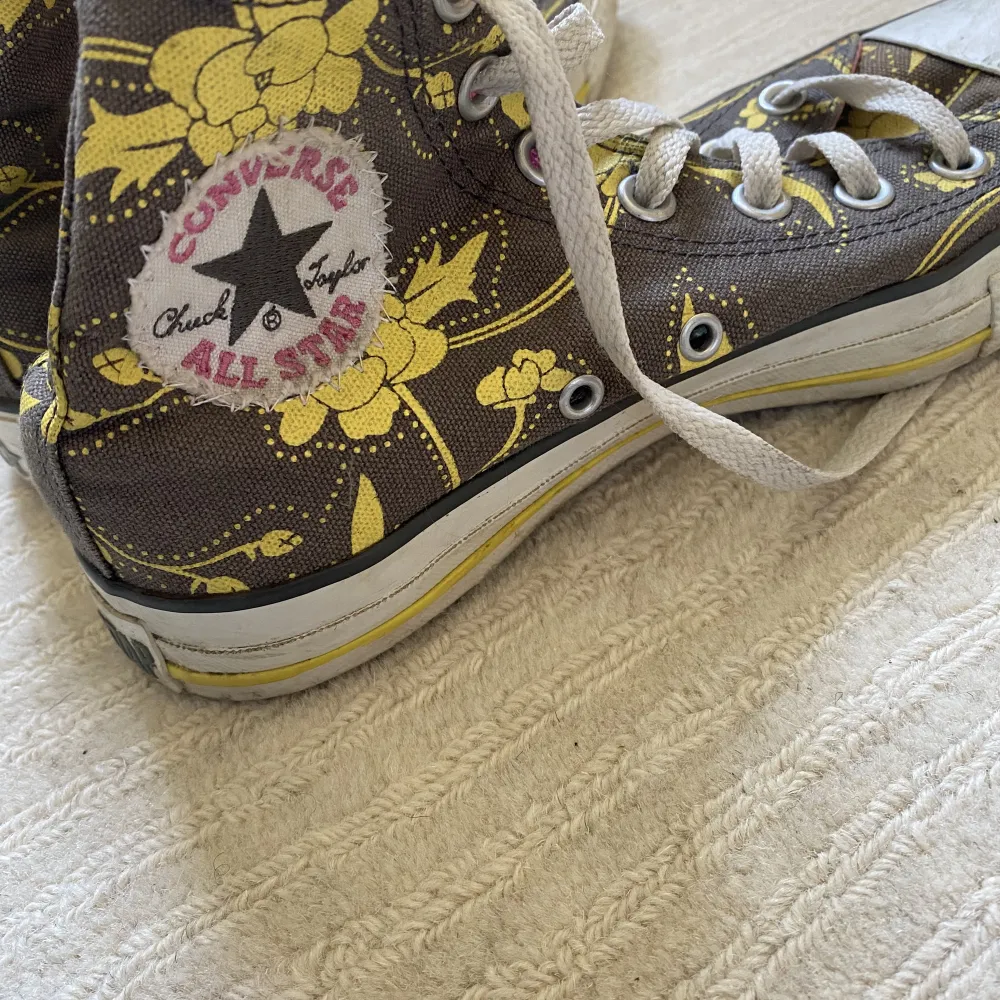 Bruna converse med gula blommor och rosa insida i storlek 37. Använda men utan defekter+ går att tvätta rena. Skor.