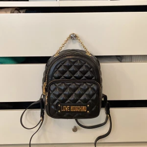 Love moschino mini väska - Äkta moschino väska. Jätte fin men kommer inte till användning längre. Fint skick. Nypris ca 3000