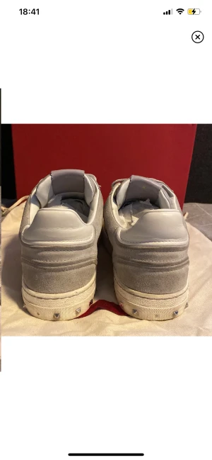 Valentino  - Säljer ett par feta valentino flycrew, grå/vita. Det är storlek 41 men passar 42. Låda och Dustbag medföljer. Saknas 1 nit på båda där av de låga priset. Annars fräscha. Köparen får stå för frakten