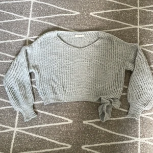 Fin stickad tröja - Säljer denna grå stickade tröjan som man knyter vid sidan. Använt skick. Skulle säga stl S