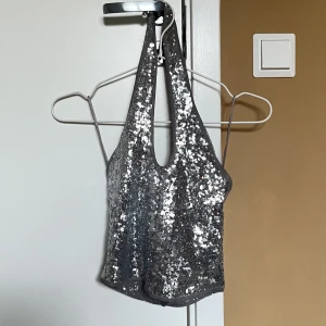Halterneck topp - Glittrig halterneck topp från Gina Tricot i storlek S. Använd en gång.