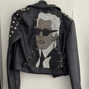 Retail jacka med Karl Lagerfeld motiv i strass på ryggen.  Finns inte i Sverige, köpte den i Rom Italien. Retail, alltså finns enbart få exemplar. 100% Vegan Leather. Saknas några nitar på ärmen.  Nypris: 289€ (3300kr) Mitt pris: 1600kr