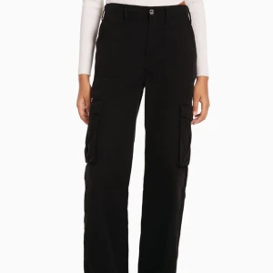 Svarta Cargobyxor - Ett par HELT NYA svarta cargobyxor som är högmidjade, köpa från zalando. Dessa är super snygga men lite för små och orkade inte skicka tillbaka.. strl 42. Nypris är 379. Säljer för 300 