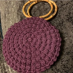 Väska - Väska i fin lila färg med ett bubbligt mönster. Väskhandtagen är av bambu.  Mått: Diameter: 23 cm, höjd ( inkl. handtag): 37 cm , bredd: 8 cm Pris: 900kr+porto OBS! Katter finns i hemmet