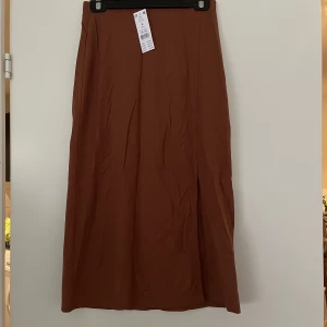 Kjol S - Oanvänd kjol med slits i strl S. Lappen kvar. 