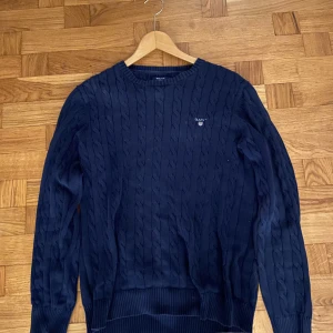 Mörkblå stickad gant tröja - Denna gant tröja säljer jag pågrund av att jag är lite för liten både i längd och i axelbredd. Tröjans original pris är 1,2 tusen men jag säljer den för endast 500 kr. Den har används en del men den är inte sönder eller något.