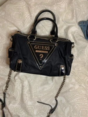 Guess  - En vintage väska som är i bra skick med några små tecken på slitage.