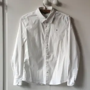 Vit Tommy Hilfiger skjorta i str 164. Modellen är BOYS SOLID STRETCH. Använd 3 gånger så inget slitage eller fläckar men har nu vuxit ur. 