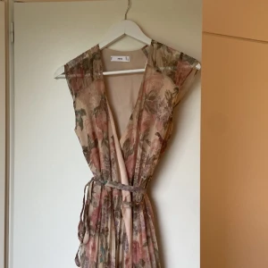 Klänning - Lång klänning från Mango, rosa men blommor. Köparen står för eventuell frakt. Endast använd en gång.