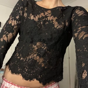 Långärmad spetstopp - Skitsnygg spetstopp perfekt nu till vintern! Svart långärmad med spets och snygga mönster. Kan användas med bara BH under eller ett linne. Köpt second hand så vet ej märket.  Säljer då jag har fler liknande och denna ej kommer till användning.