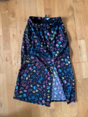 Kjol från hm - Kjol från hm med kort innerkjol och lång ytterkjol. Småblommigt mönster på ytterkjolen. Sparsamt använd. Skriv privat för fler bilder.