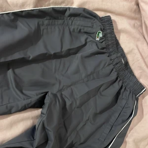 Lacoste windbreaker byxor - Ser helt nya ut. Justerbara ben 